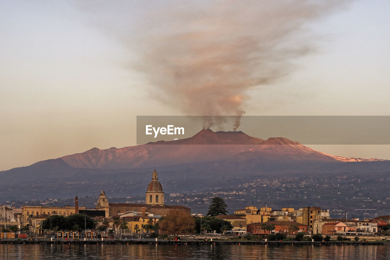 Panorama of the city of riposto with the background of the erupting etna