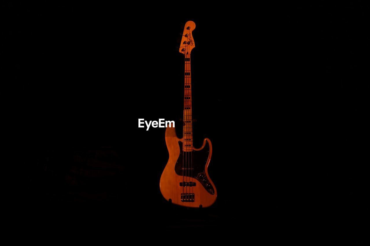 GUITAR AGAINST SKY OVER BLACK BACKGROUND