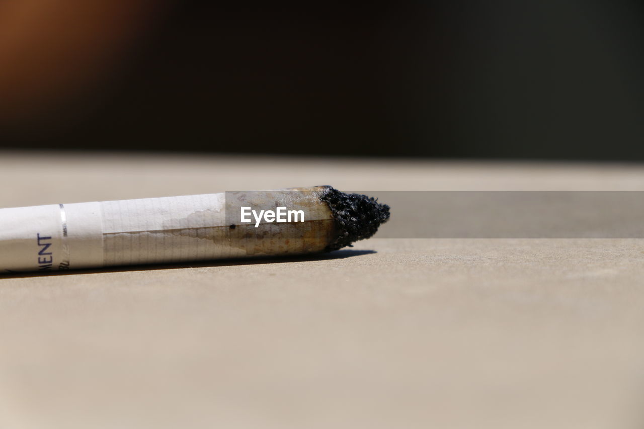 Close-up of burnt cigarette on table