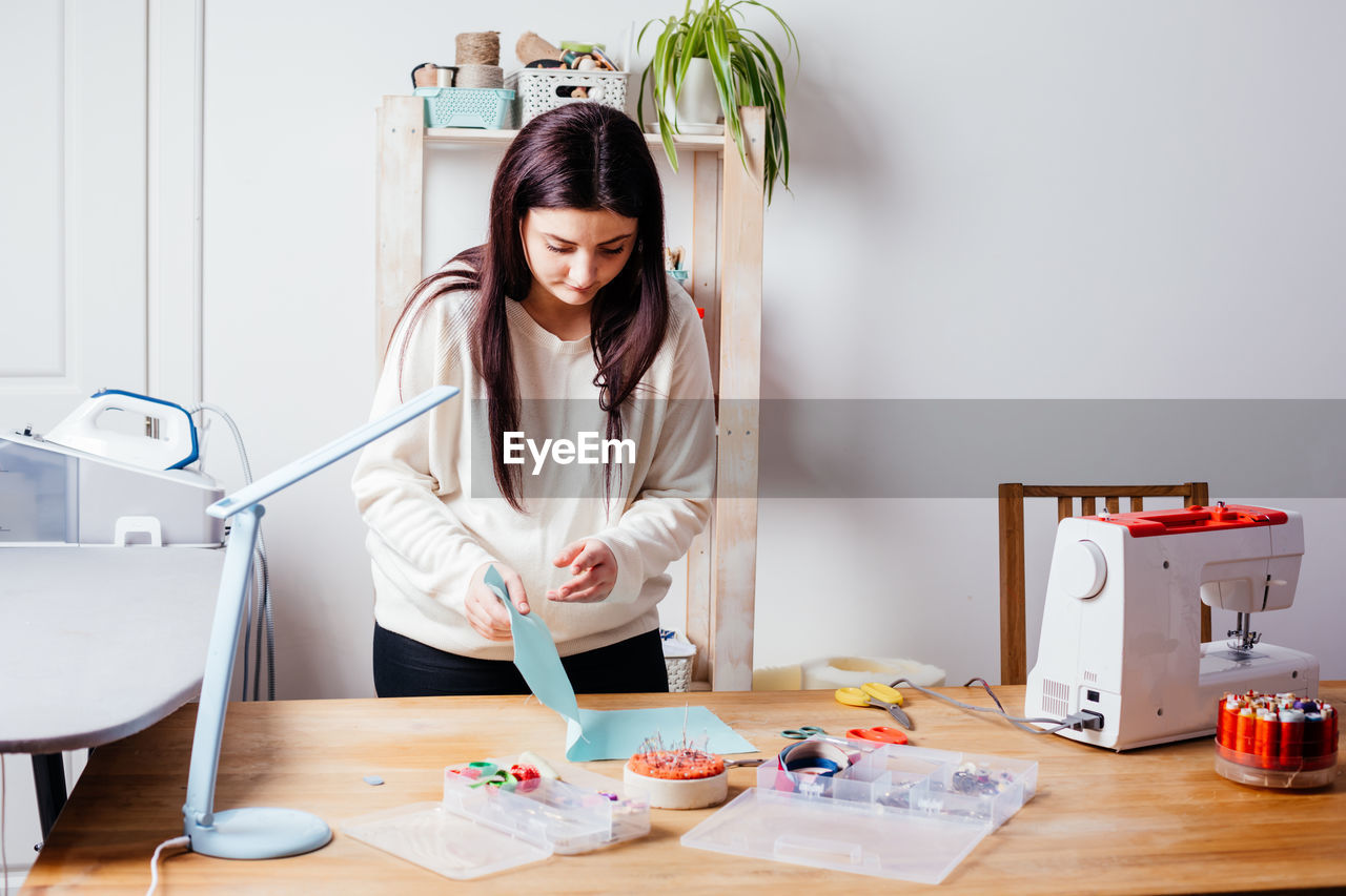 Young woman doing craft by table