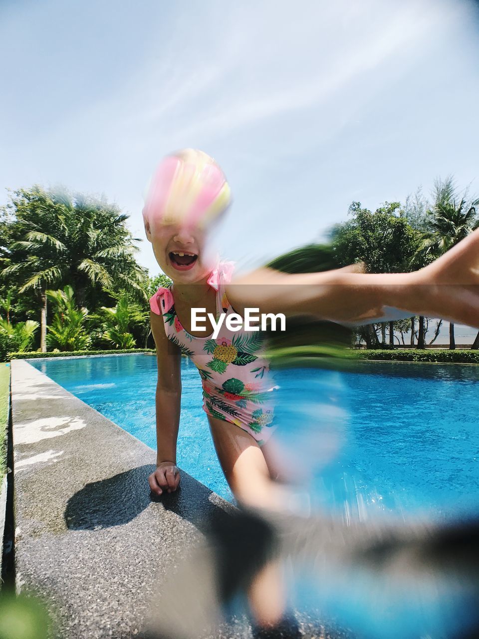 Girl in swimming pool against sky