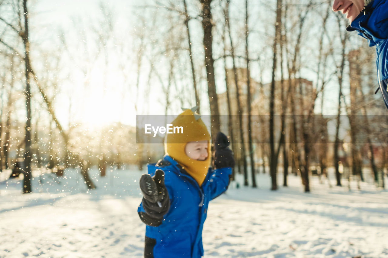 Father and son playing with snow in forest