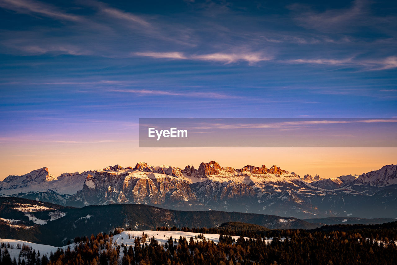 Scenic view of snowcapped mountains against sky during sunset