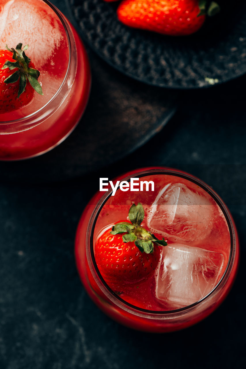 Two strawberry cocktail with ice on dark background fom above