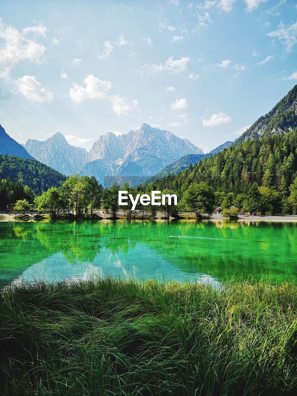 Scenic view of lake by mountains against sky