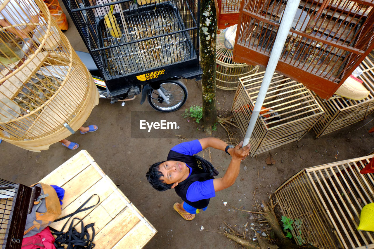 high angle view, men, adult, working, full length, occupation, business, women, shopping cart, two people, basket, architecture, business finance and industry, lifestyles, container, day, clothing, retail, directly above, small business, city, outdoors, market