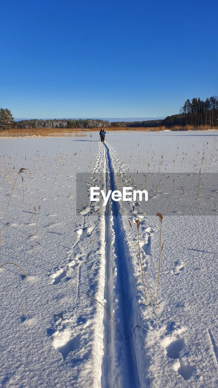 SCENIC VIEW OF SNOWY FIELD AGAINST CLEAR BLUE SKY