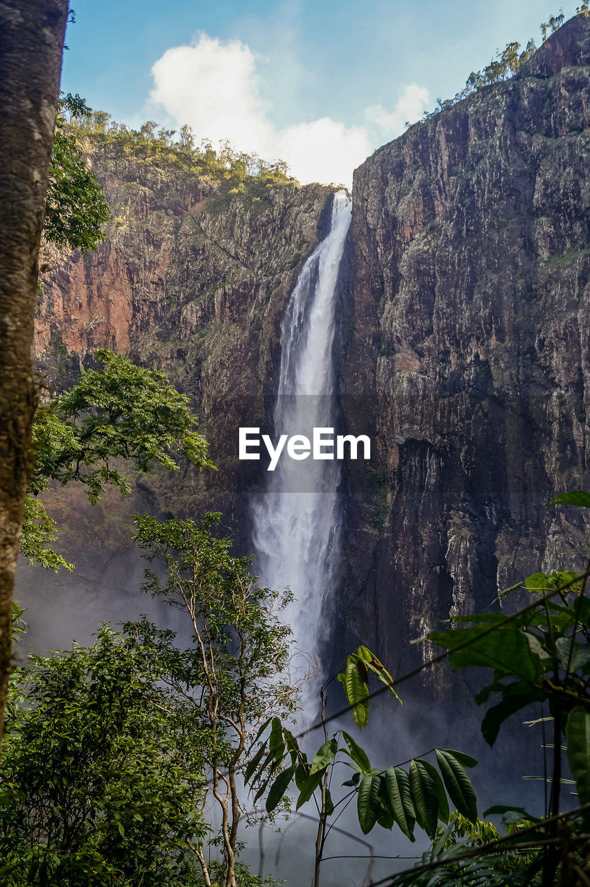 SCENIC VIEW OF WATERFALL AGAINST SKY