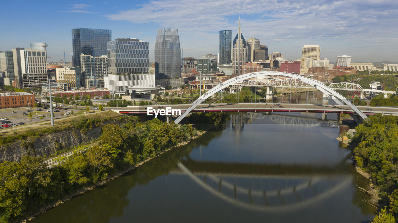 BRIDGE OVER LAKE BY BUILDINGS IN CITY