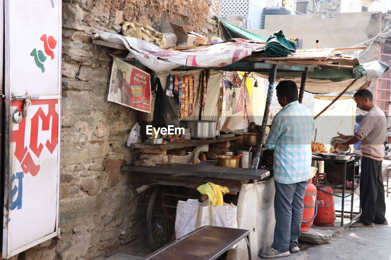 REAR VIEW OF PEOPLE AT MARKET STALL