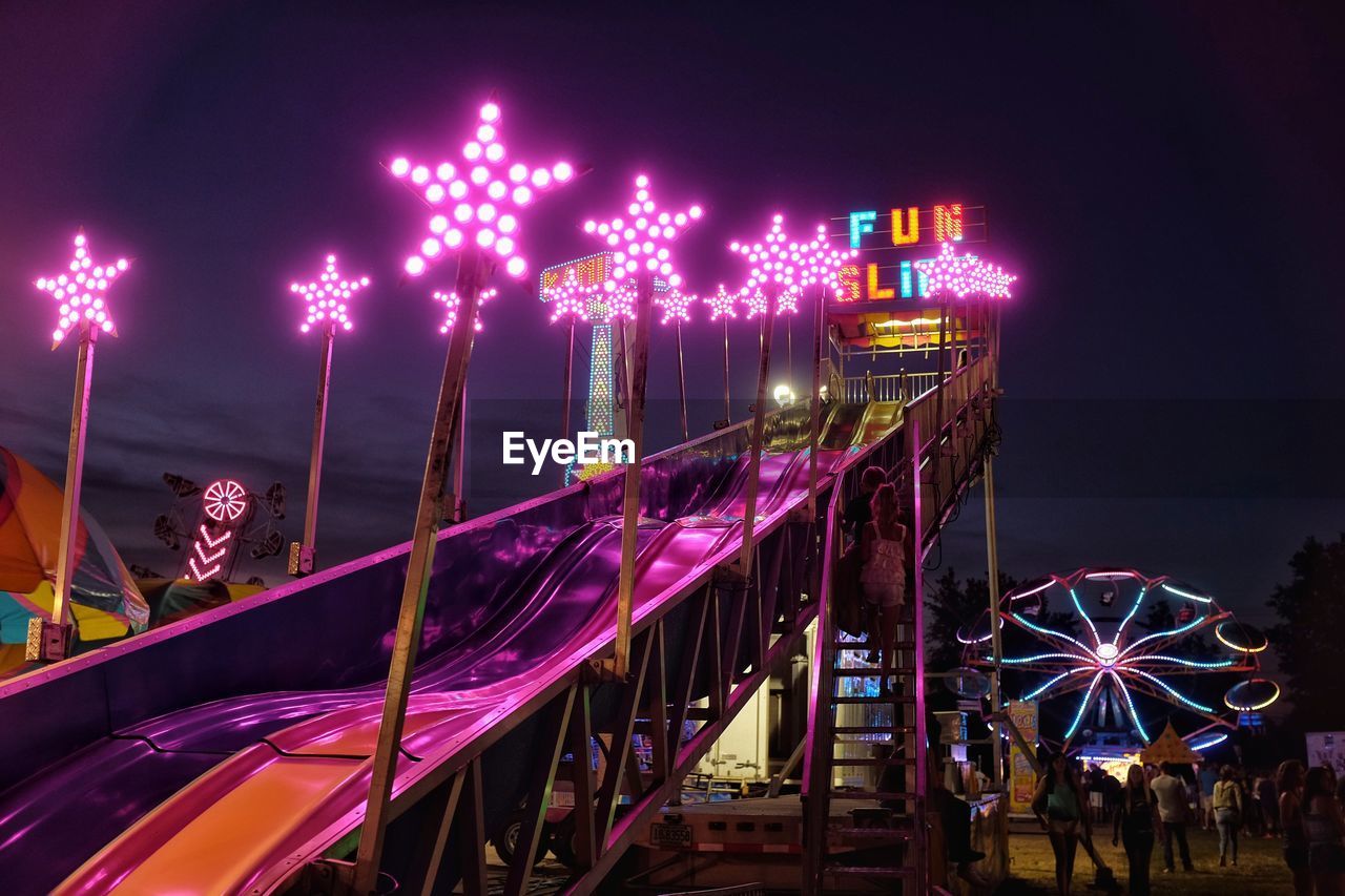 Illuminated amusement park rides at night