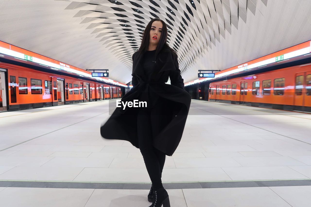 low section of woman walking on railroad station platform