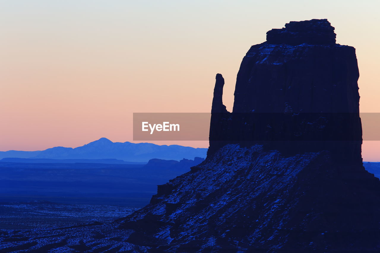 Silhouette rock formations against sky during sunset