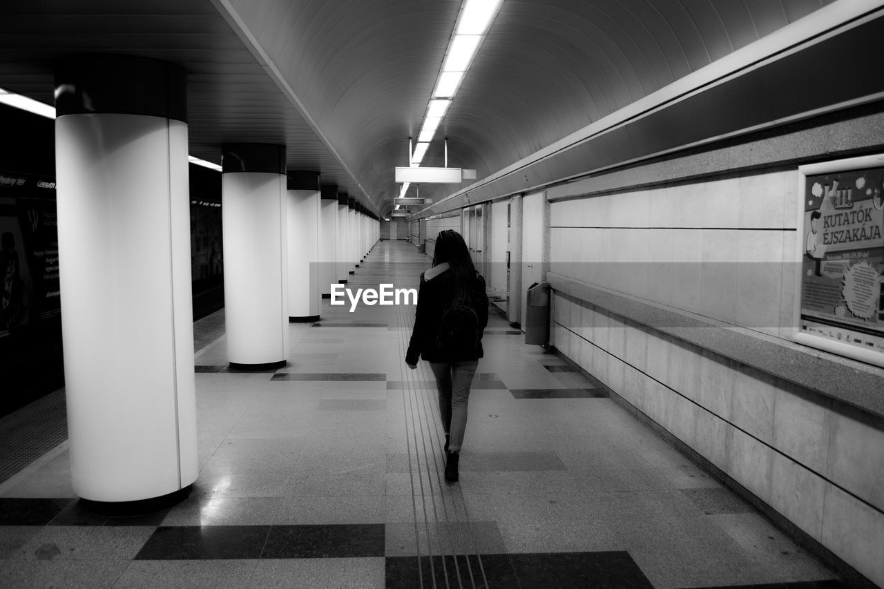 Rear view of woman walking at metro station