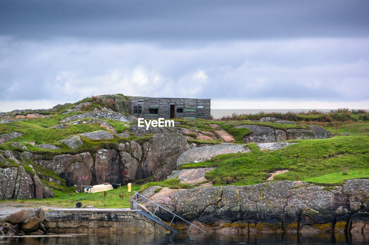 Building by rocks against sky