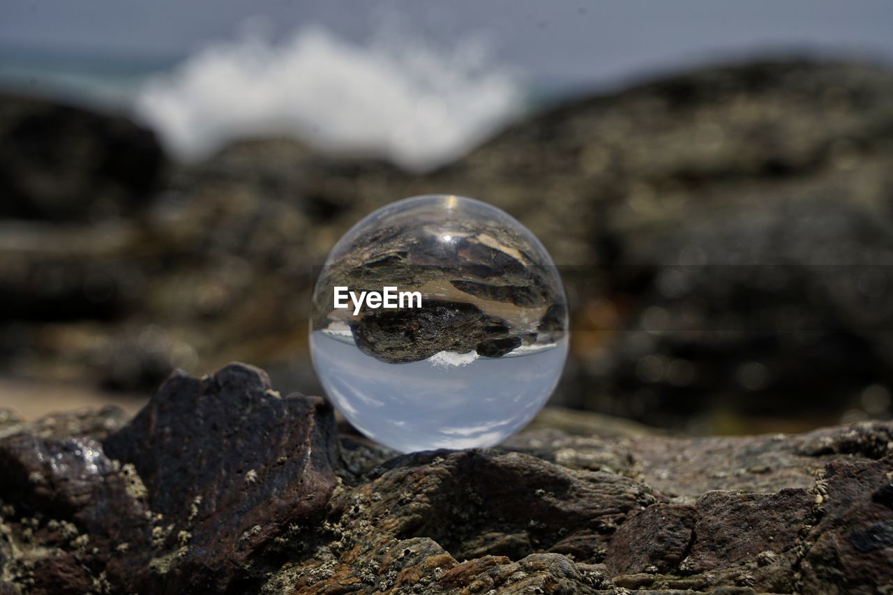 CLOSE-UP OF CRYSTAL BALL ON ROCKS