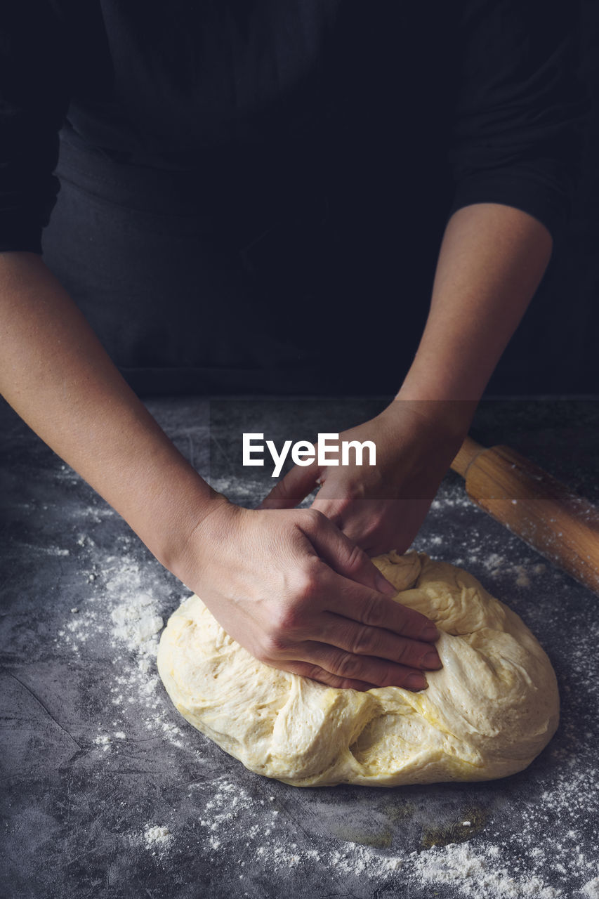 MIDSECTION OF WOMAN PREPARING BREAD