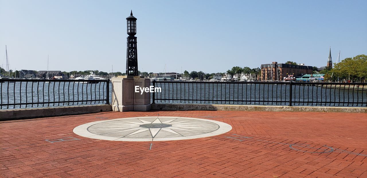 INFORMATION SIGN BY RIVER AGAINST BUILDINGS IN CITY