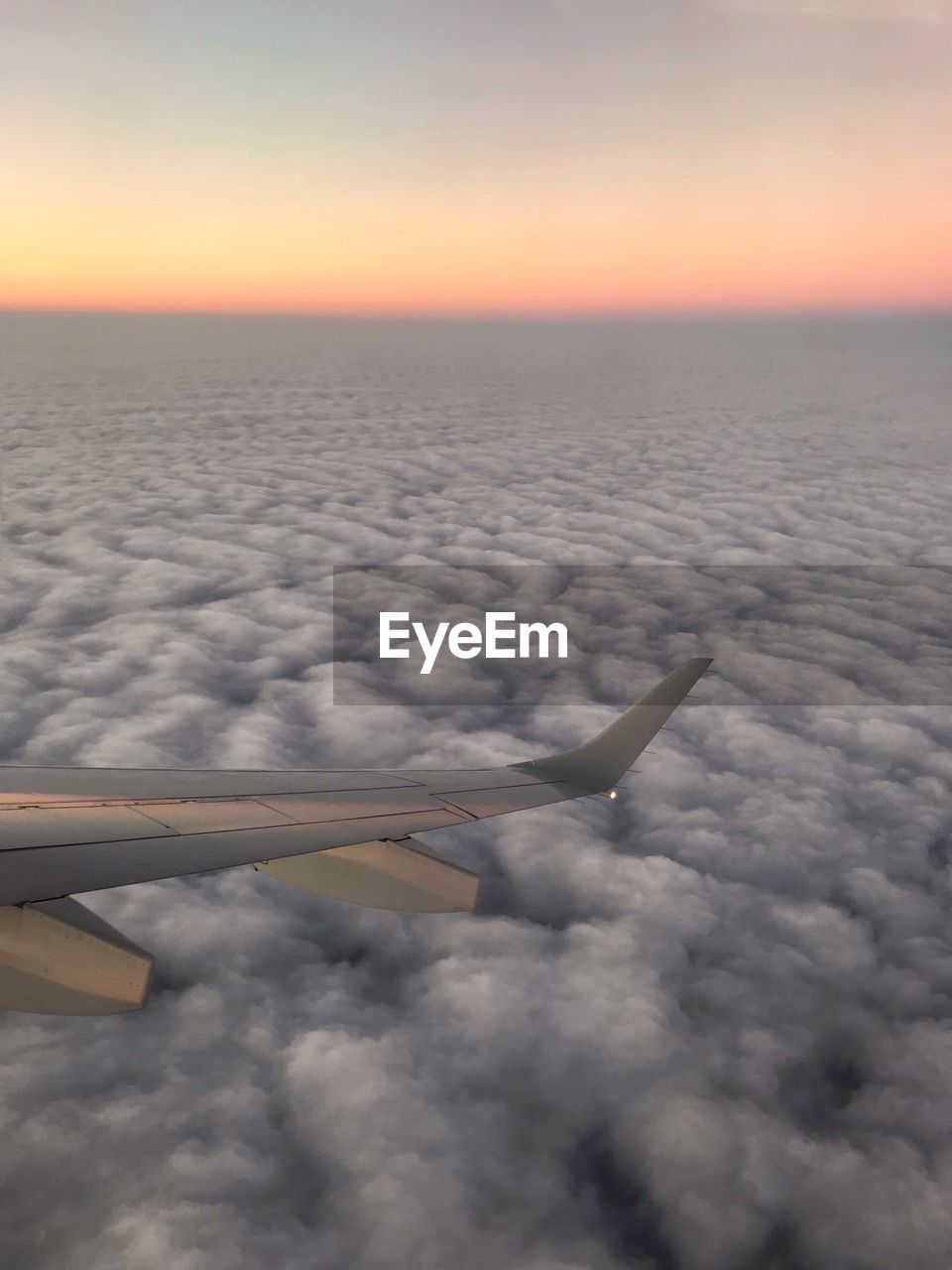 AERIAL VIEW OF AIRPLANE WING AGAINST SKY