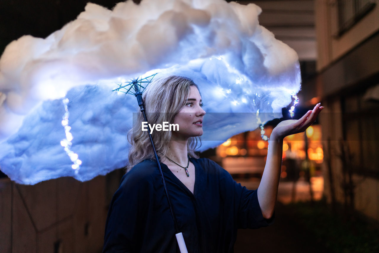 Digital composite image woman holding cloud shaped umbrella