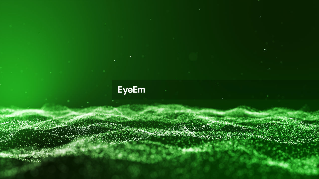 Abstract image of glittering particles against green background