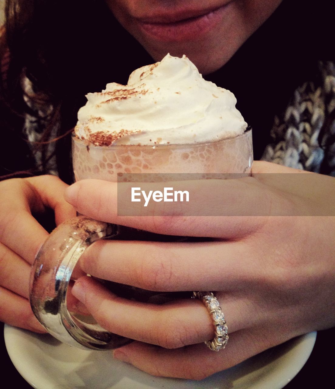 Midsection of woman holding hot chocolate in glass
