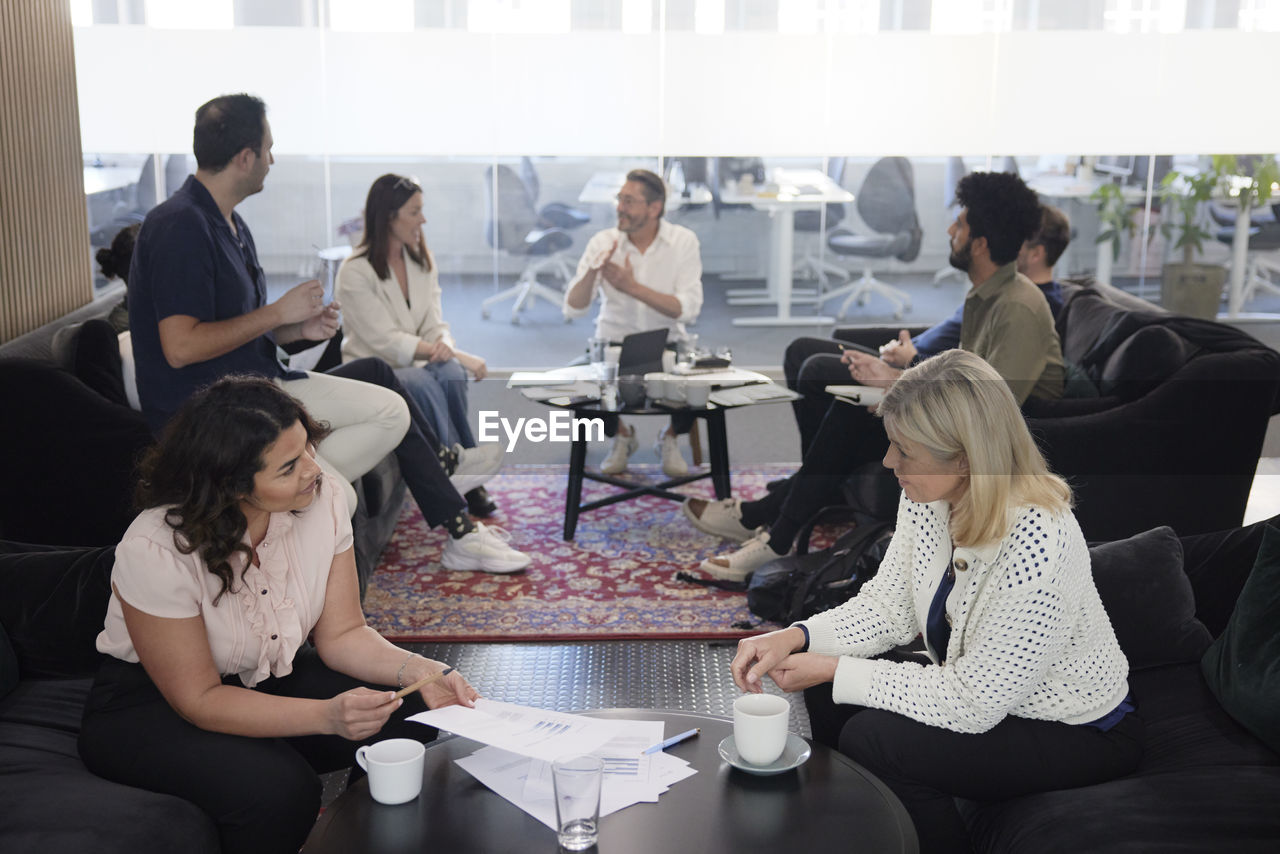 Group of business people having meeting in lobby