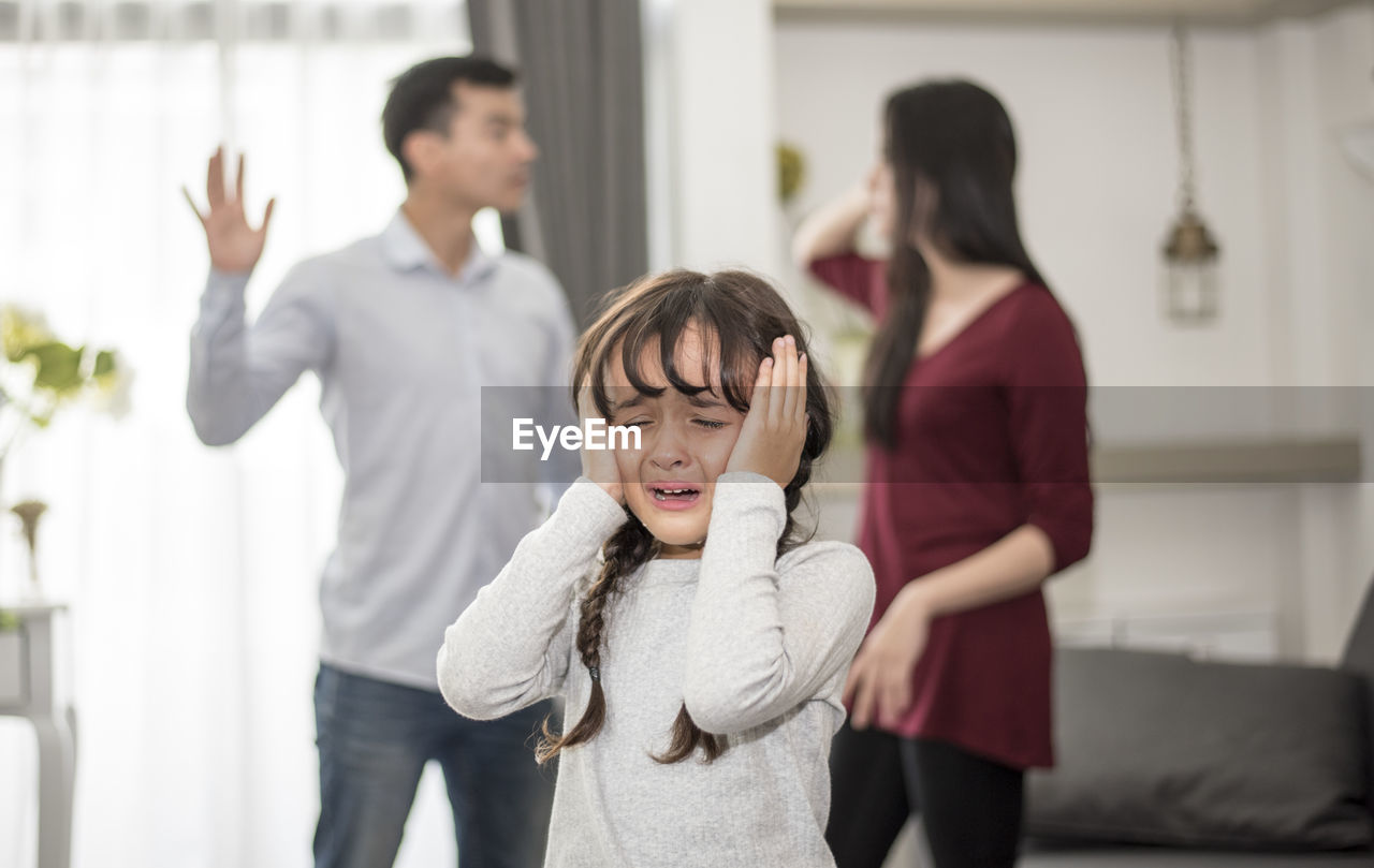 Girl crying while parents arguing at home