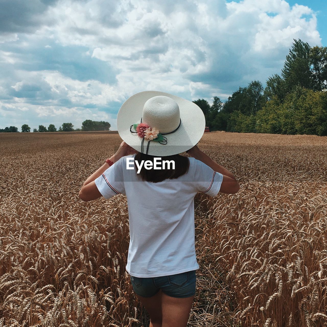 Rear view of man wearing hat standing on field