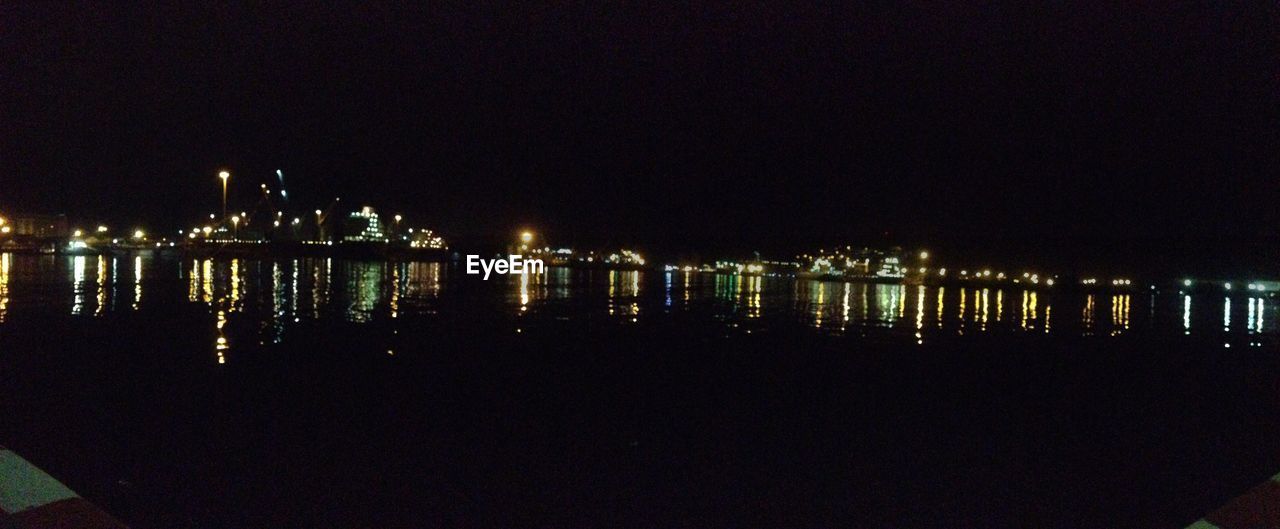 REFLECTION OF ILLUMINATED PIER IN WATER