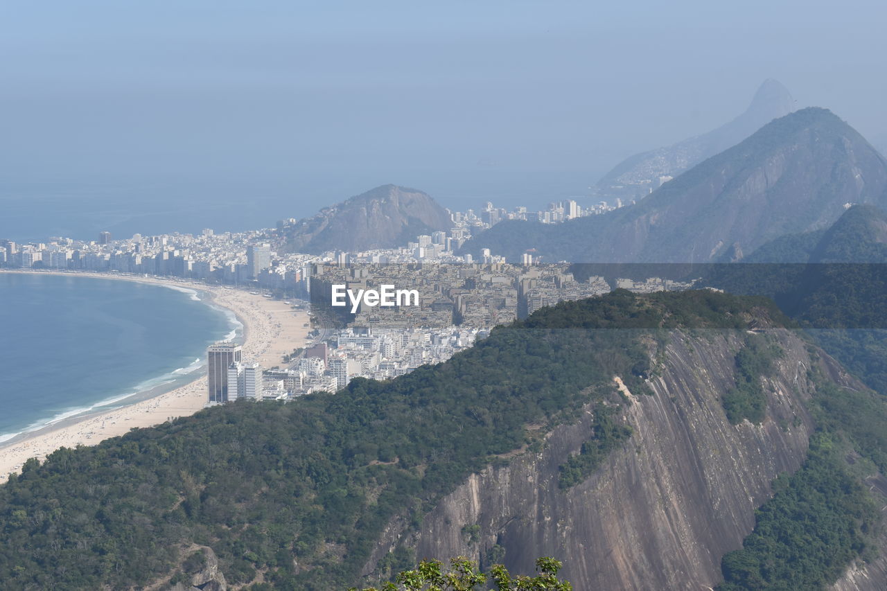 High angle view of city by sea against sky