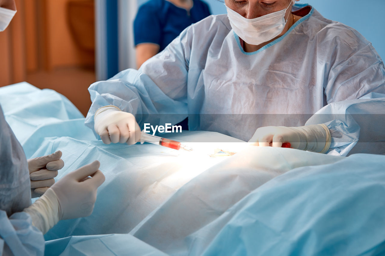 midsection of doctor examining patient on bed