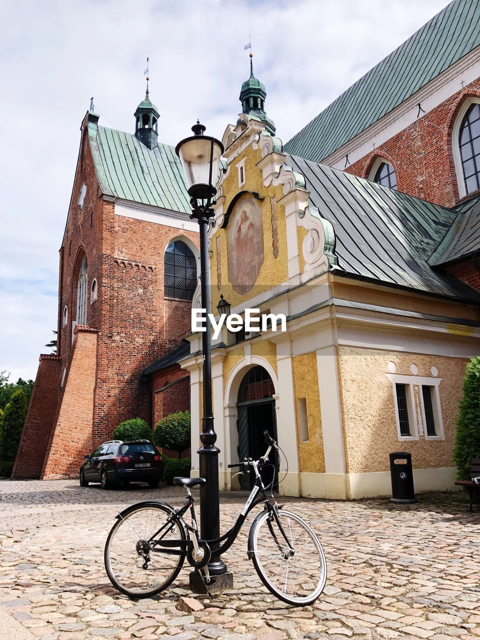 Bicycle parked outside church against sky