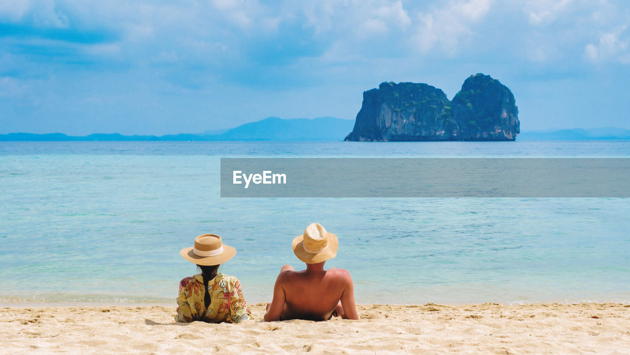 rear view of woman sitting at beach