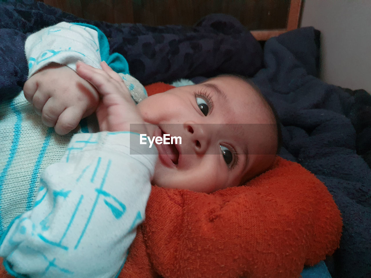PORTRAIT OF CUTE BABY BOY LYING ON BED