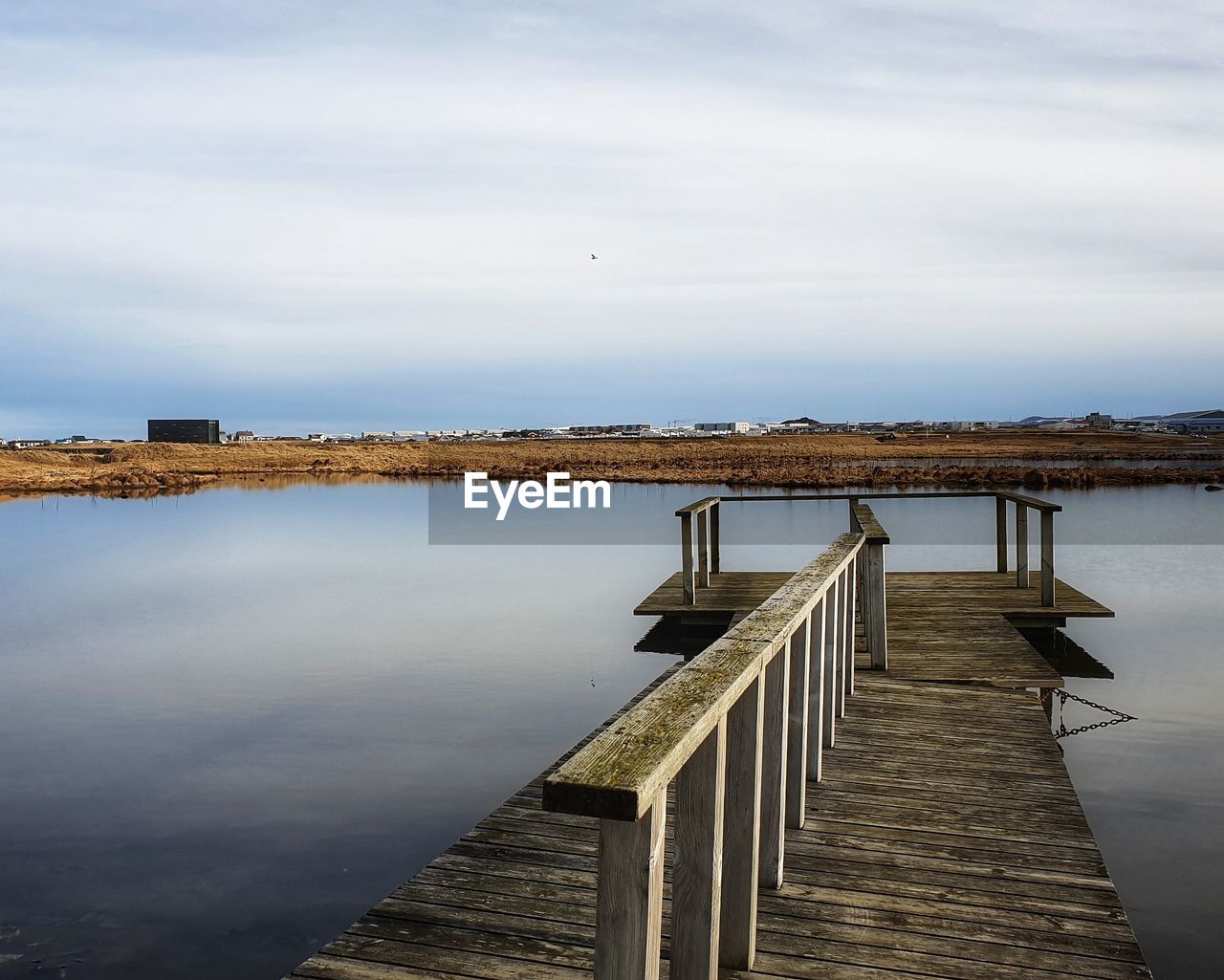 Pier over lake against sky