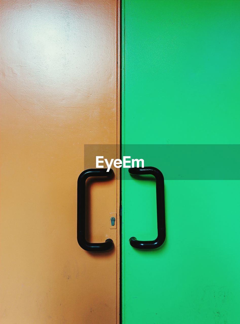 Full frame shot of orange and green doors with handles