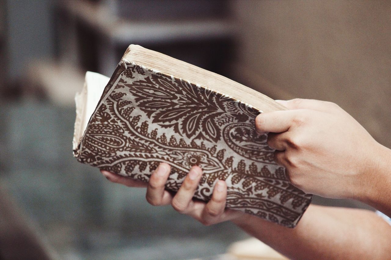 Cropped image of person holding book