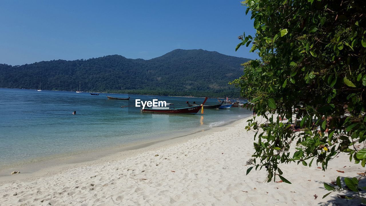 Boats moored on sea at ko lipe