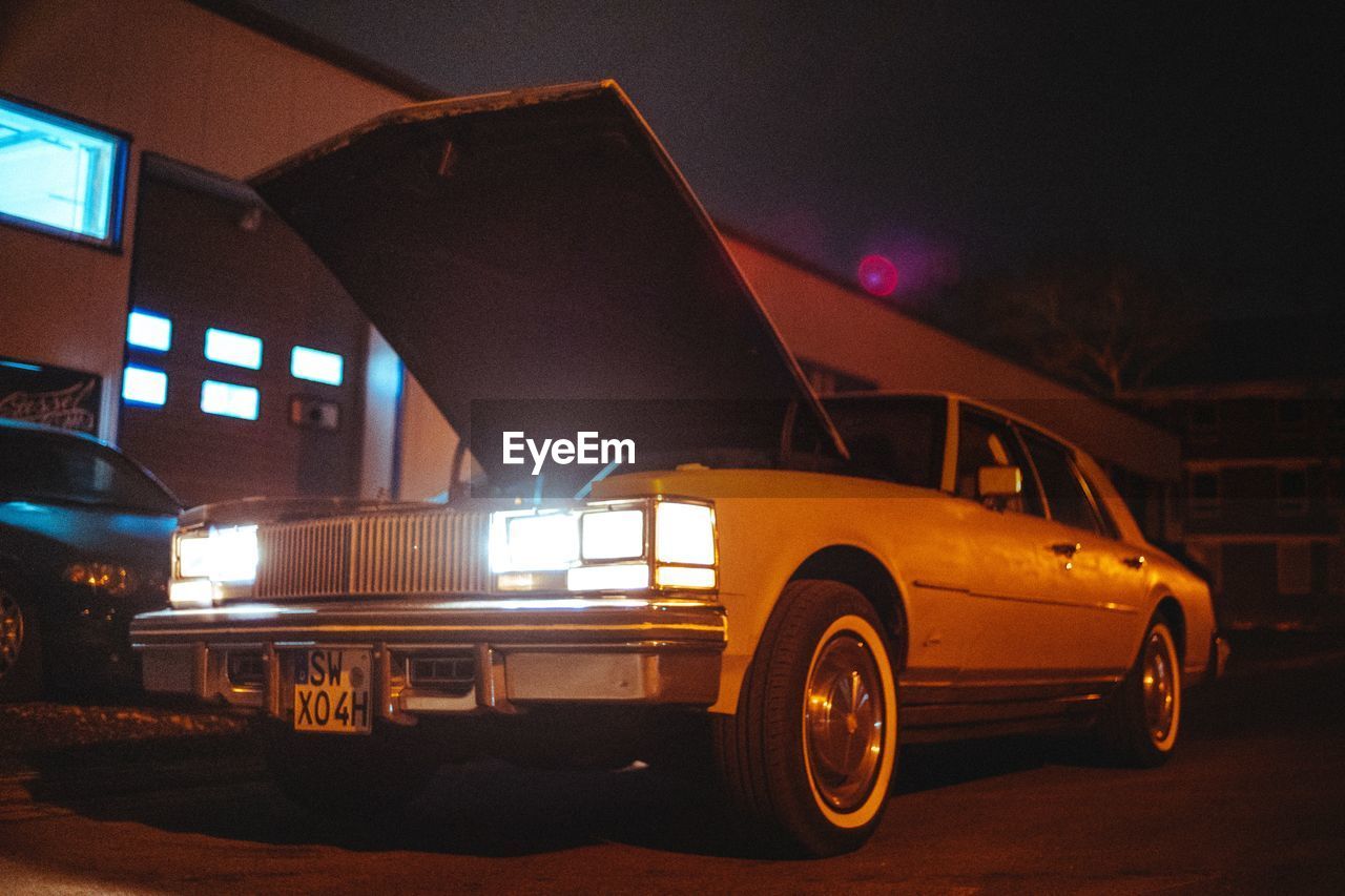 CAR PARKED ON ILLUMINATED STREET