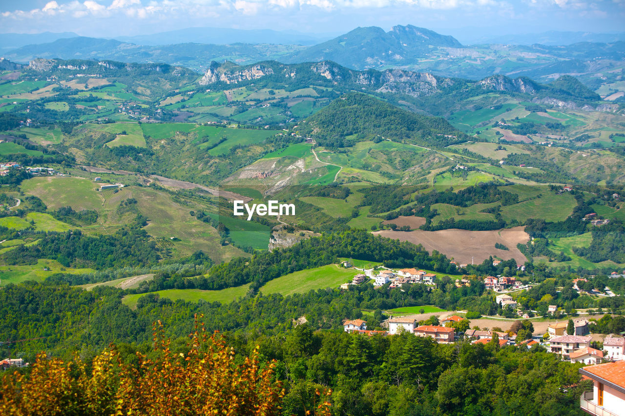 landscape, environment, scenics - nature, land, rural scene, building, beauty in nature, architecture, mountain range, nature, plant, mountain, agriculture, field, house, residential district, valley, village, building exterior, tree, city, aerial photography, built structure, sky, farm, no people, green, tranquility, high angle view, town, rural area, social issues, outdoors, travel, tranquil scene, crop, aerial view, idyllic, growth, environmental conservation, travel destinations, forest, plateau, summer, meadow, day, cloud, flower, multi colored, tourism, foliage