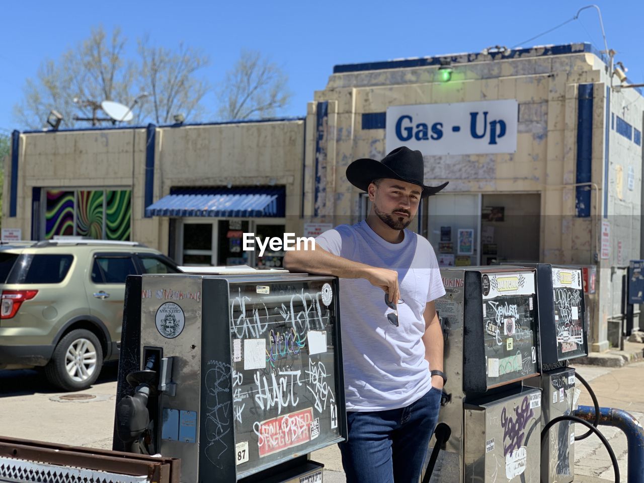 Side view of man standing at gass station