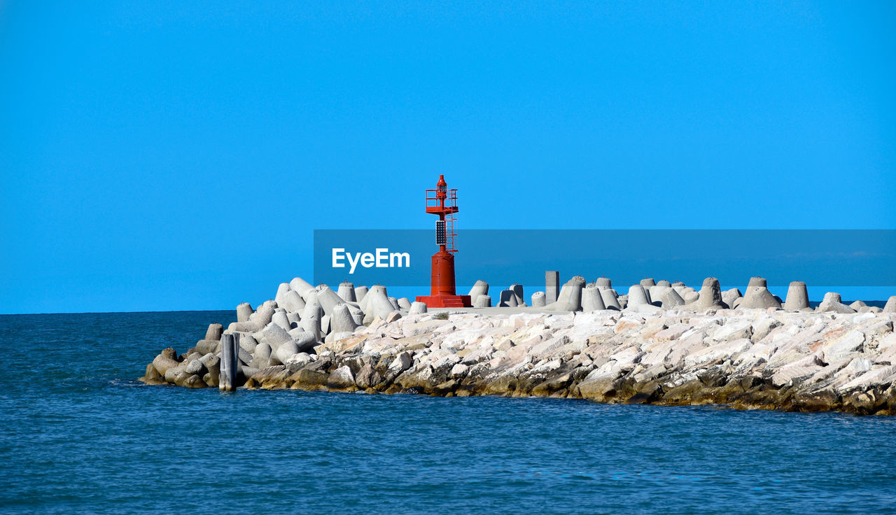 lighthouse by sea against sky