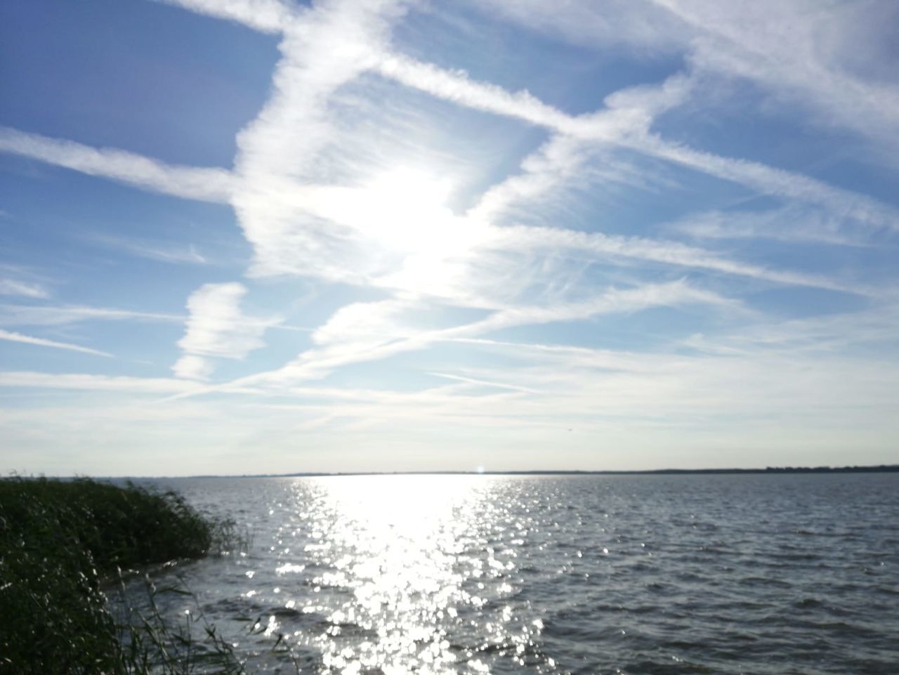 sky, water, horizon, sea, cloud, beauty in nature, scenics - nature, sunlight, nature, ocean, horizon over water, tranquility, shore, tranquil scene, body of water, blue, no people, idyllic, coast, day, outdoors, environment, wave, reflection, seascape, sun, summer, sunbeam, travel, land, wind wave, beach
