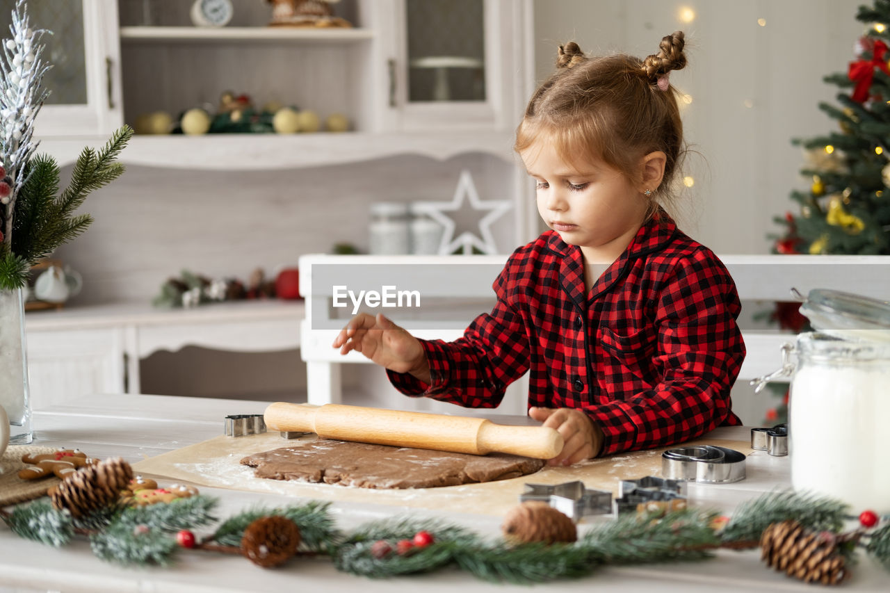 portrait of boy playing with christmas tree at home