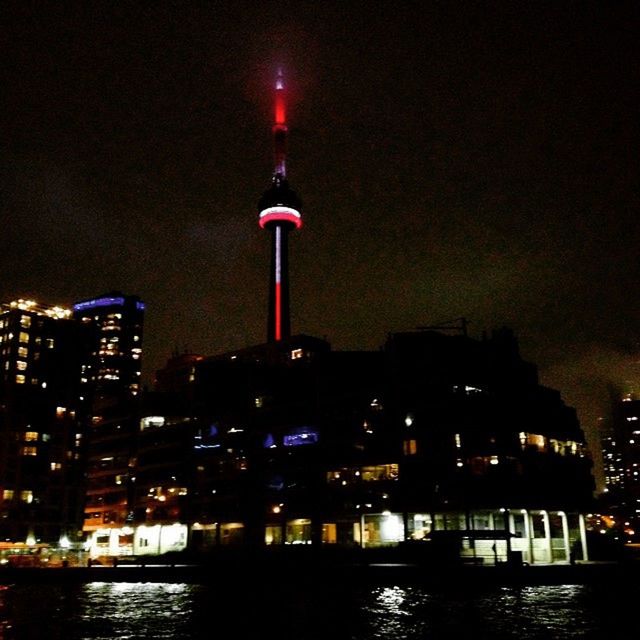 LOW ANGLE VIEW OF ILLUMINATED TOWER AT NIGHT