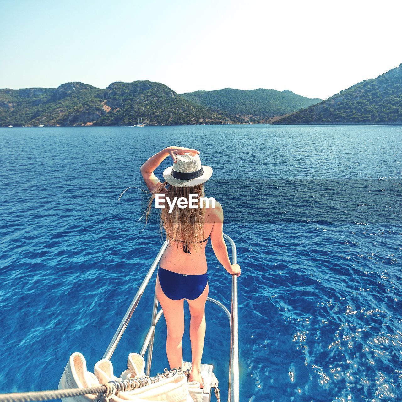 REAR VIEW OF YOUNG WOMAN ON BEACH