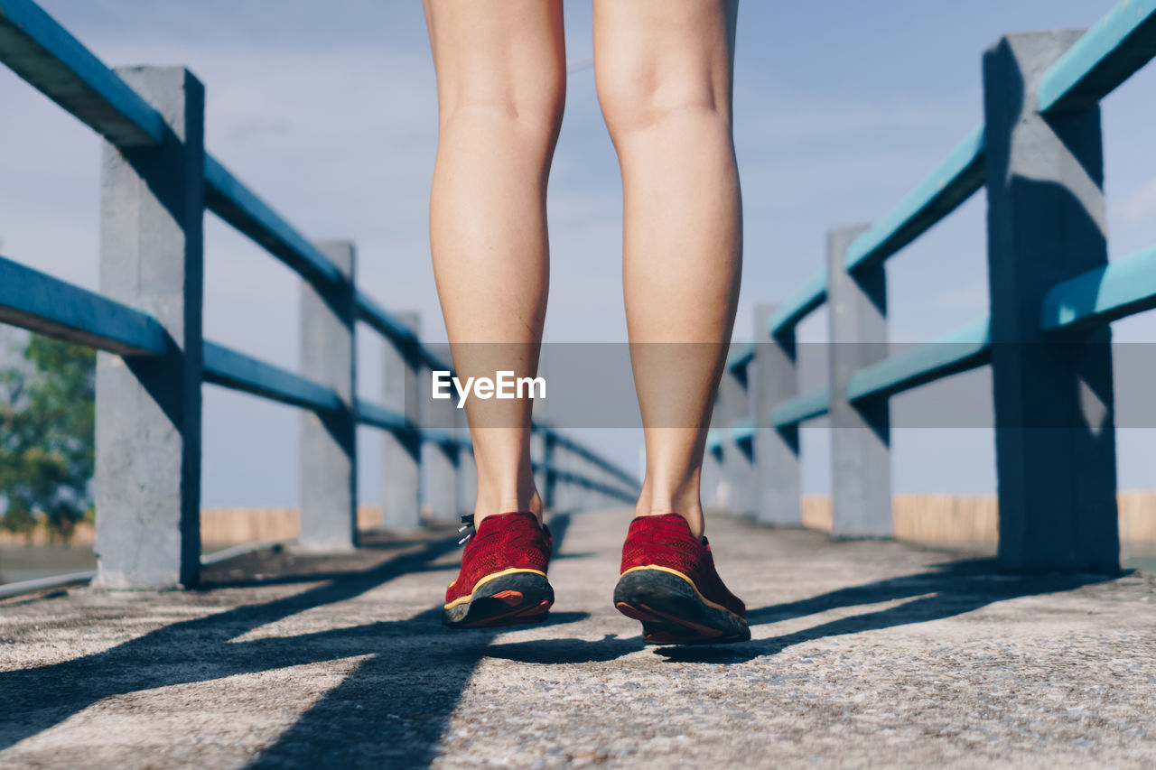 Low section of woman standing on bridge