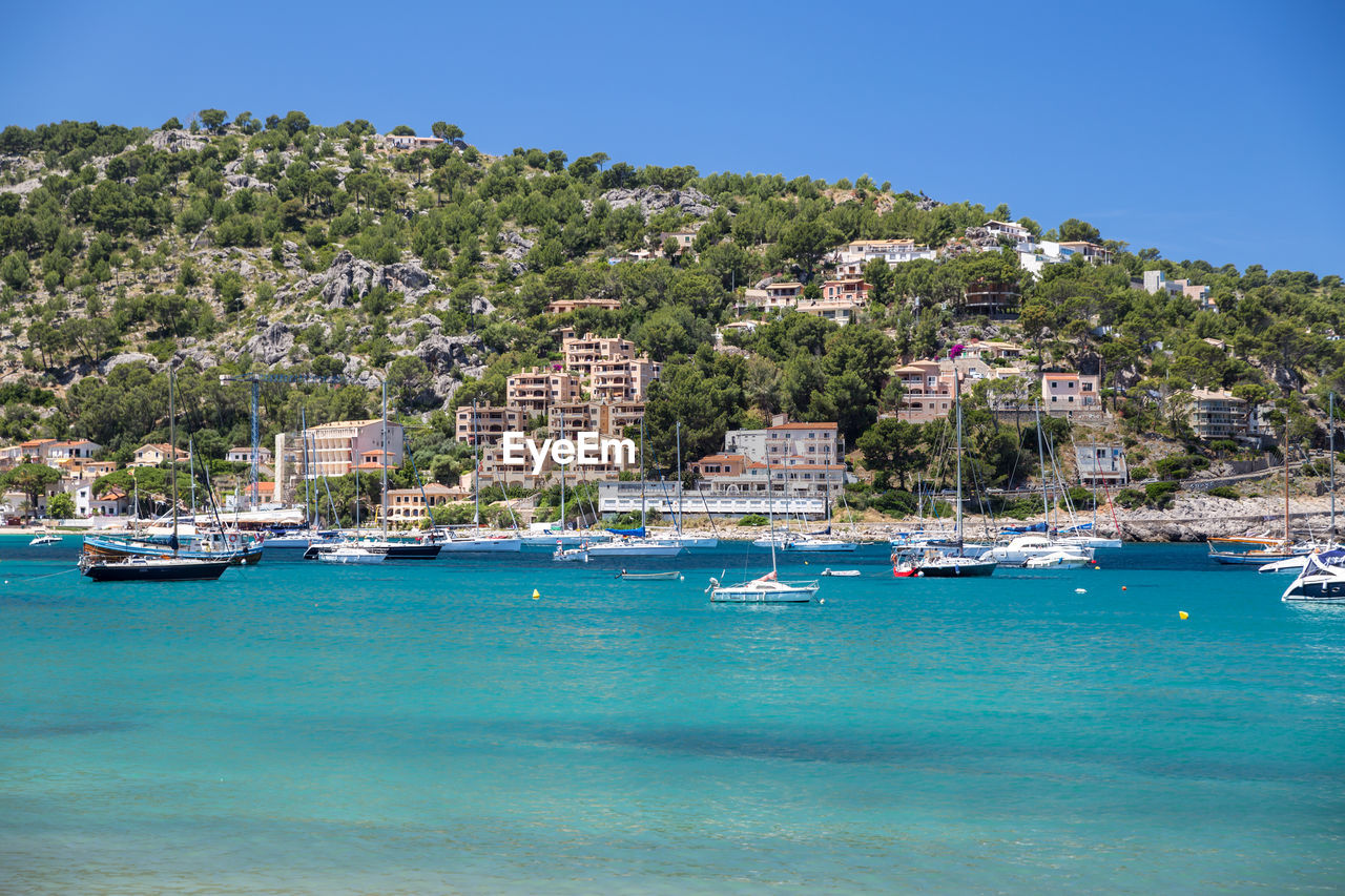 Sailboats in sea against clear blue sky