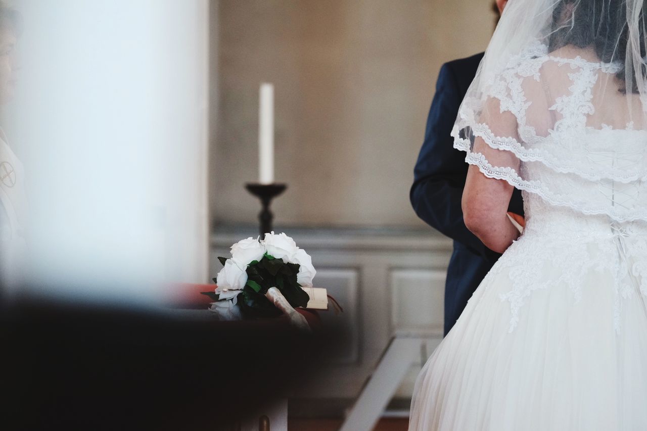 Midsection of couple standing in church during wedding ceremony